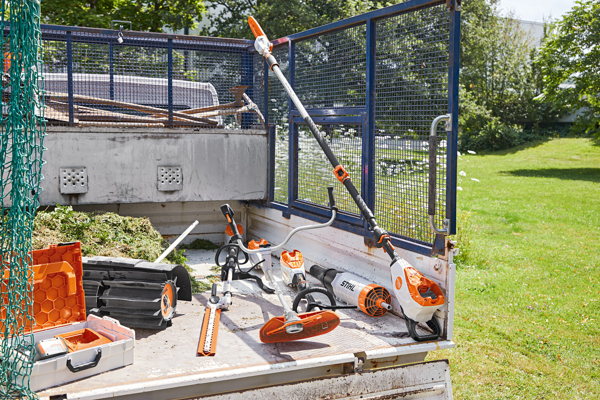 Vehículo con podadora de altura STIHL HTA 135, cortasetos de altura HLA 135, desmalezadora FSA 135 y KMA 135 en la superficie de carga