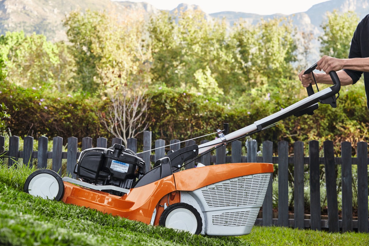 Un hombre corta una pendiente con un cortacésped de gasolina STIHL RM 756 GC