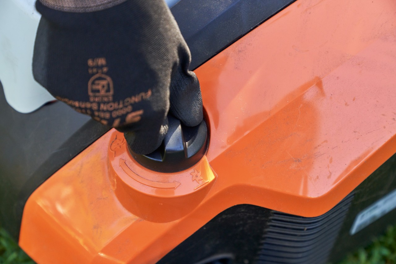 Una mano con guante de trabajo STIHL FUNCTION SENSOTOUCH gira la empuñadura del escarificador de batería STIHL RLA 240.
