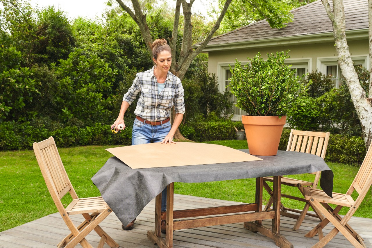 Una mujer prepara todos los materiales para la poda ornamental de un boj en una mesa de jardín