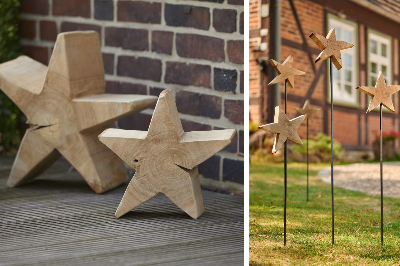 Estrellas de madera hechas a mano delante de una pared y estrellas insertadas en una varilla delante de una casa
