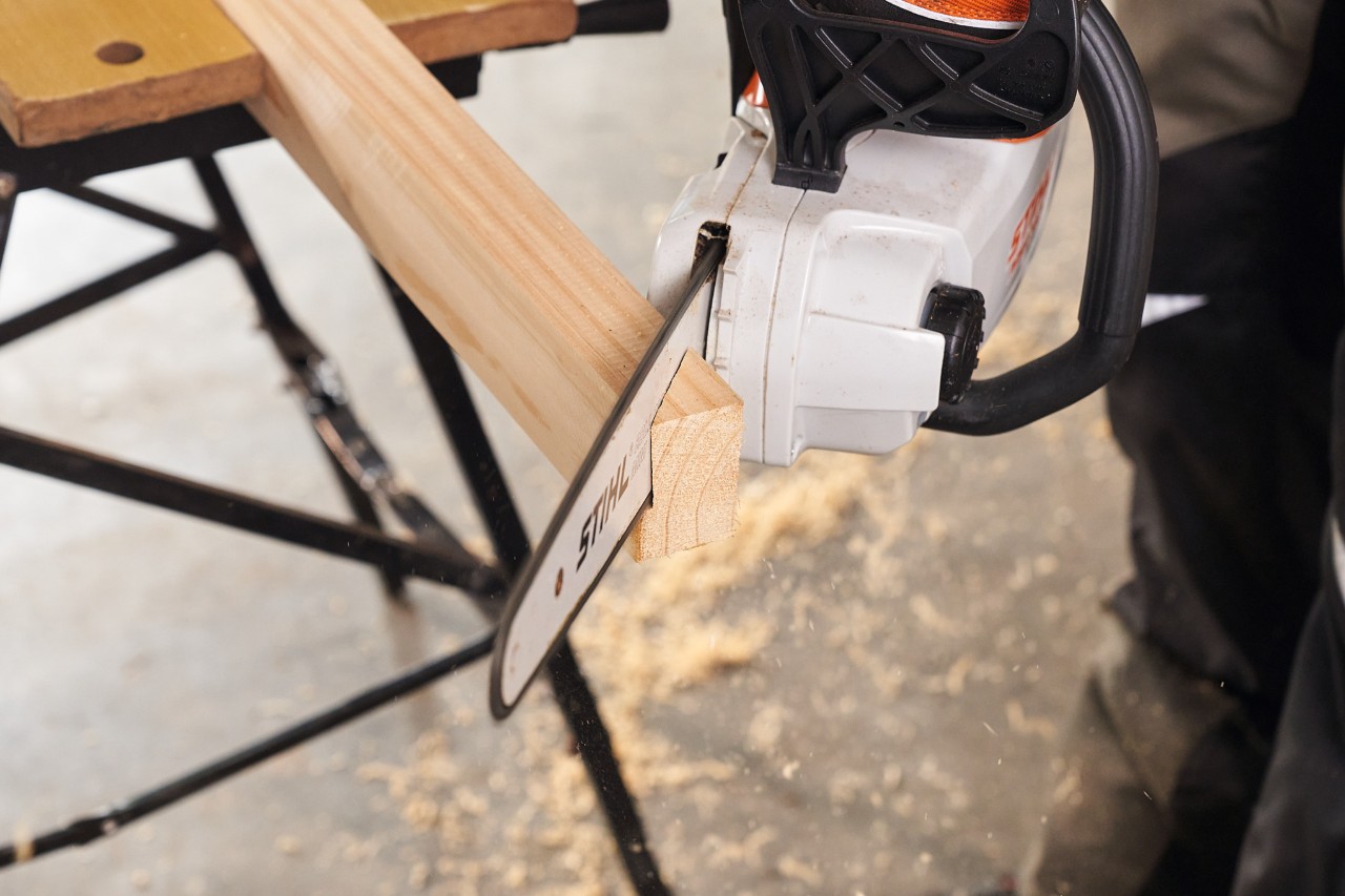 Con una motosierra de batería STIHL MSA 140 se cortan a medida las vigas de madera para las patas de una pantalla de privacidad    