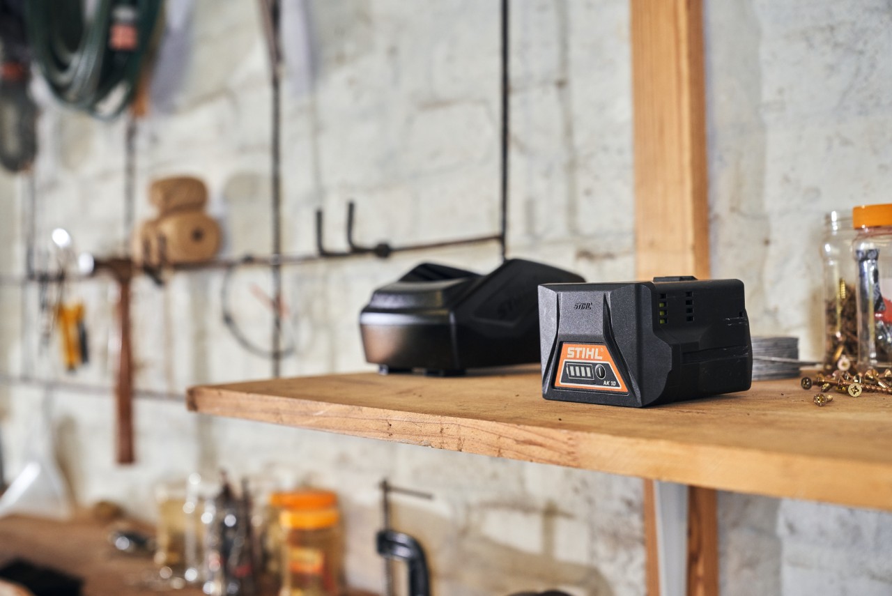 Dos baterías con tecnología de batería STIHL reposan en un estante de un taller